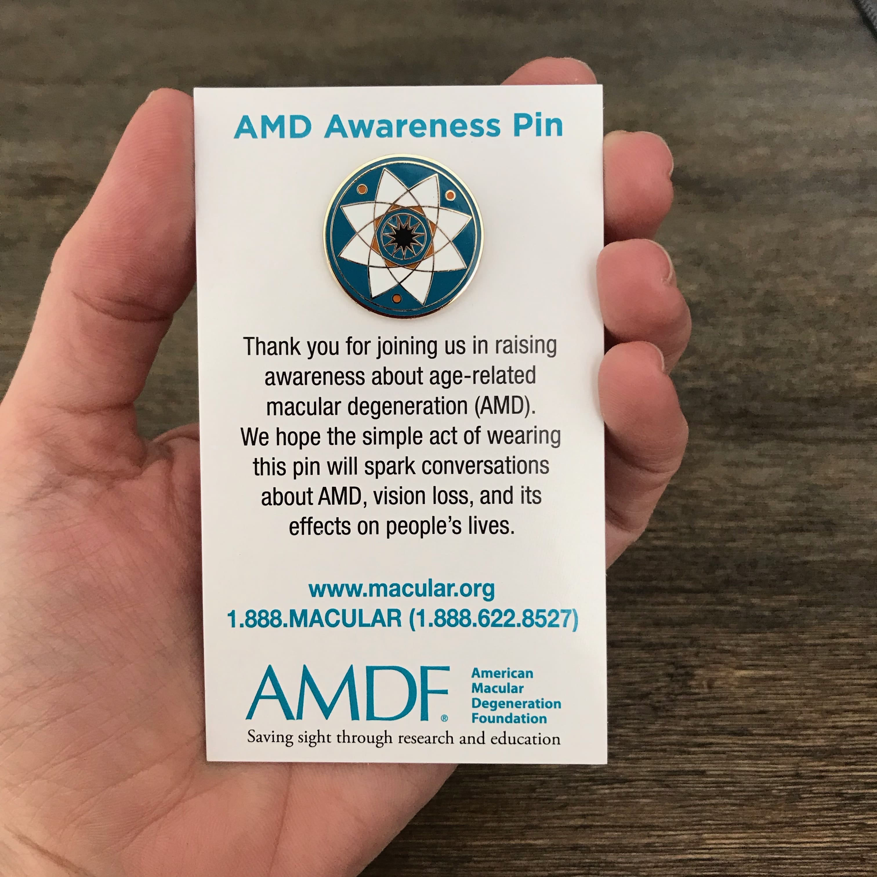 Age-related macular degeneration awareness pin mounted on backing card.