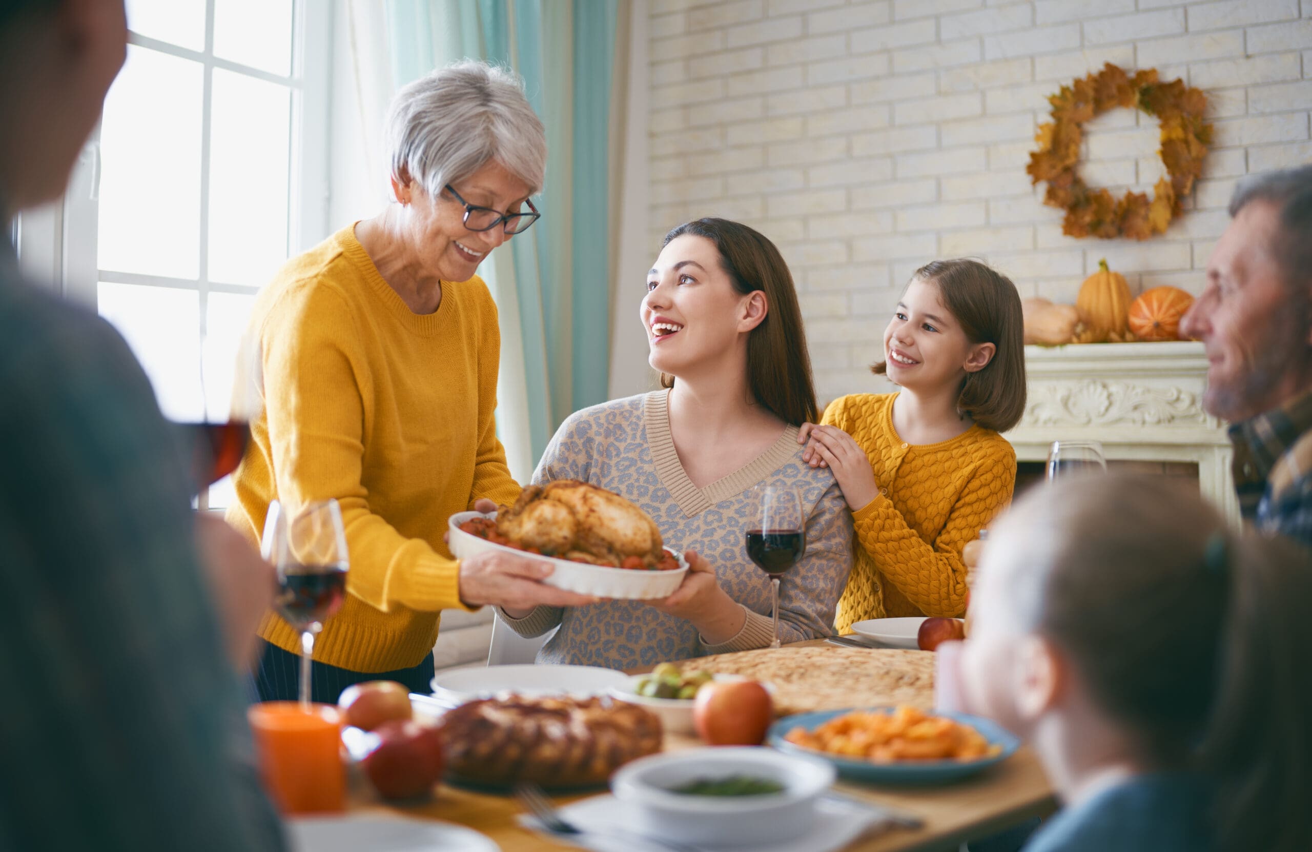 Autumn feast. Family sitting at the table and celebrating holiday. Grandparents, mother, father and children. Traditional dinner.